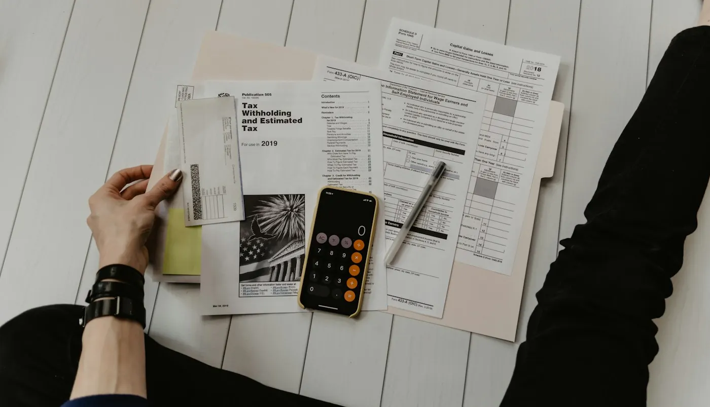 Calculator, pen and financial paperwork on a desk